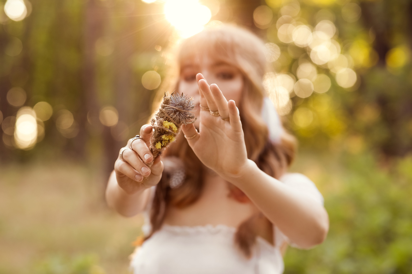 Young Female Shaman with Herbs in Forest